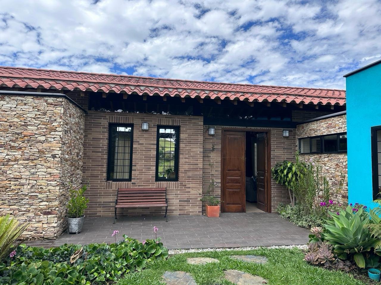 Fachada principal en ladrillo y piedra con entrada en madera