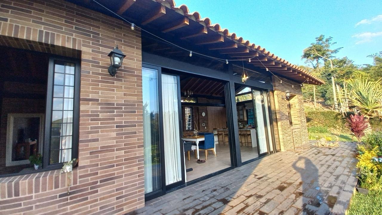 Terraza exterior en adoquín con ventanales corredizos